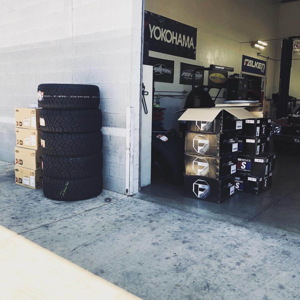 Tires sitting outside the Ace Automotive repair shop and multiple banners on a wall; Tire services in Queen Creek, AZ