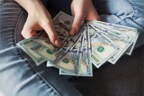 APA Total Car Care in Queen Creek, AZ counting money and giving tips to save money on car repairs and services